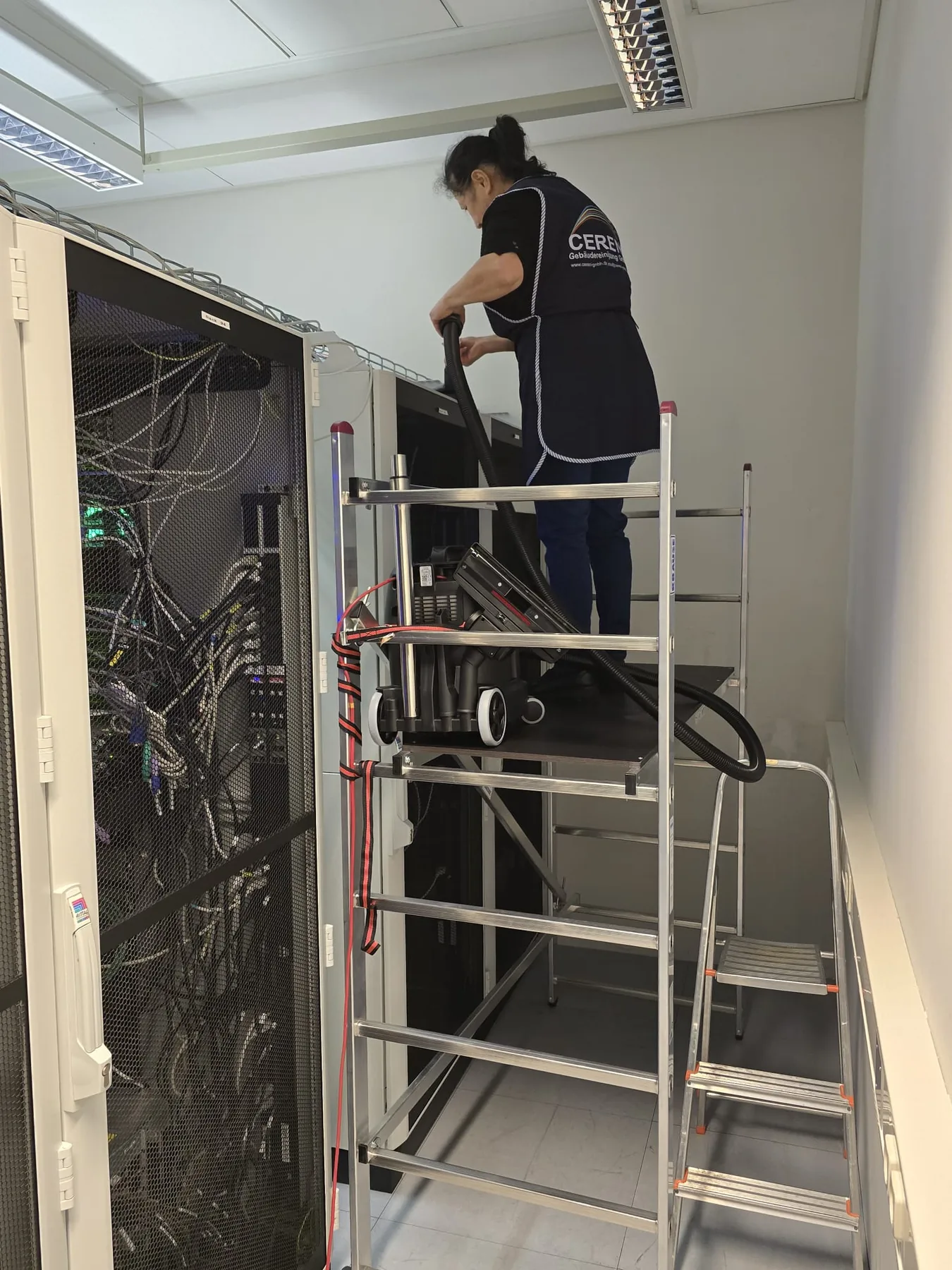 Cereni-Mitarbeiterin beim Absaugen eines sensiblen technischen Arbeitsbereichs